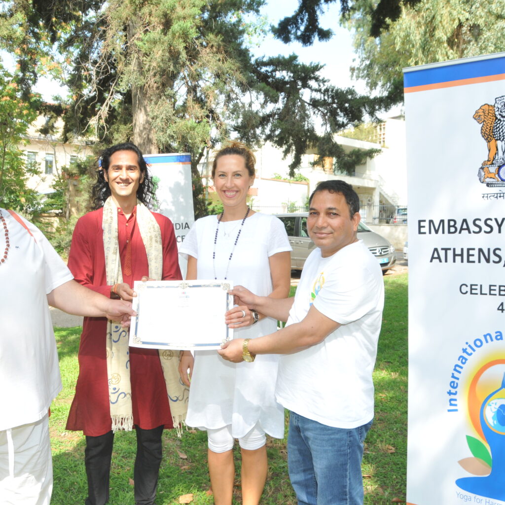 Giving my student a teacher training completion certificate with the head of the chancery  on right and the president of the Greek yoga association on the left